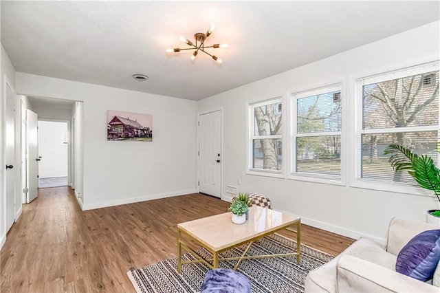 living room with wood-type flooring and a notable chandelier