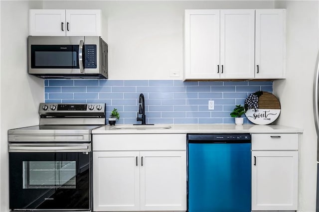 kitchen featuring decorative backsplash, white cabinetry, sink, and appliances with stainless steel finishes