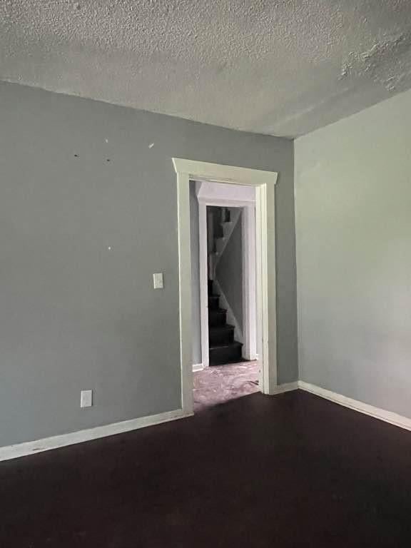 carpeted spare room featuring a textured ceiling