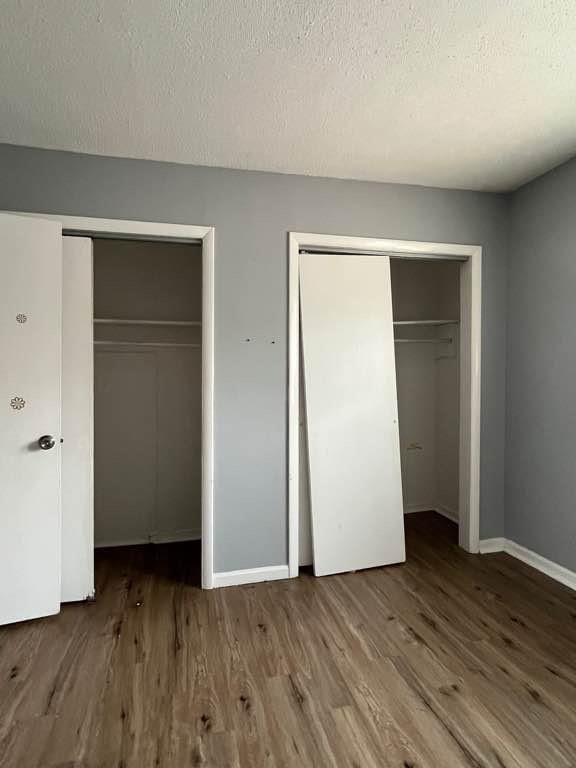 unfurnished bedroom with hardwood / wood-style floors and a textured ceiling