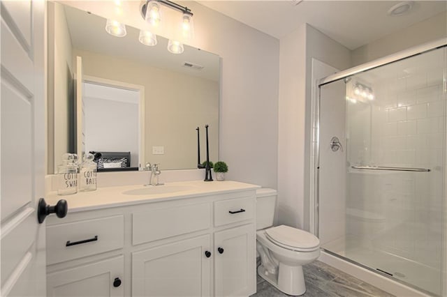 bathroom featuring hardwood / wood-style floors, a shower with shower door, vanity, and toilet