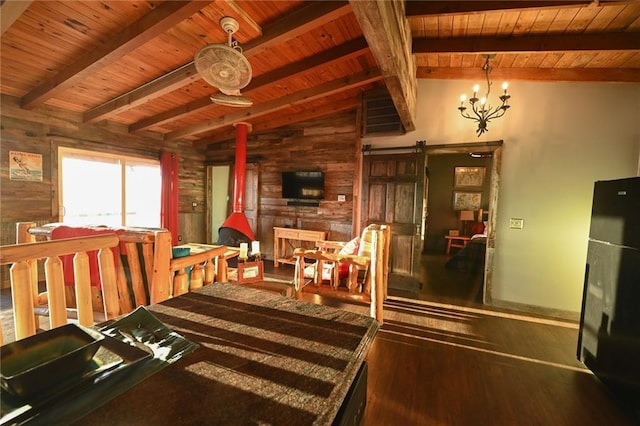 dining space with a barn door, wood walls, dark hardwood / wood-style flooring, and lofted ceiling with beams