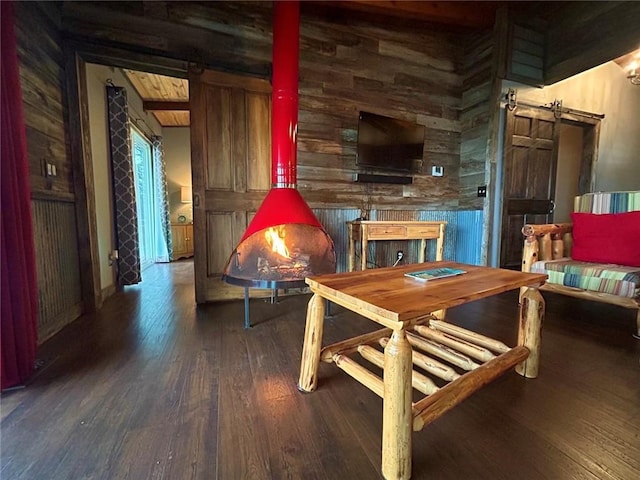 interior space featuring a barn door, dark hardwood / wood-style floors, and wood walls