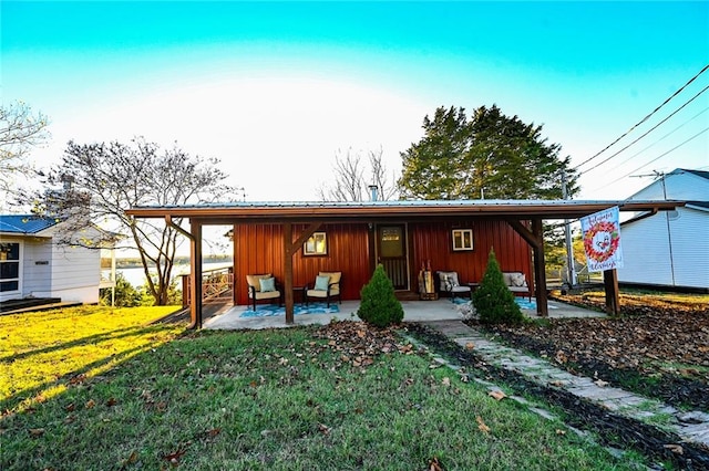 back of house with a lawn and a patio