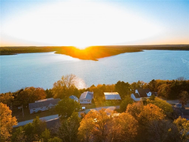 aerial view at dusk featuring a water view