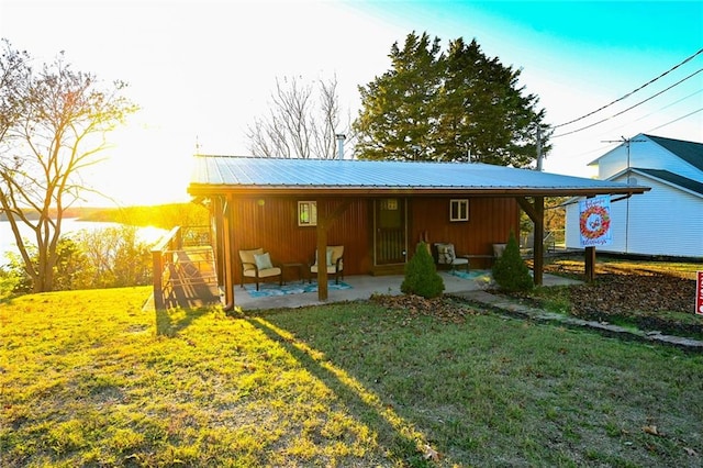 back of house with a lawn and a patio