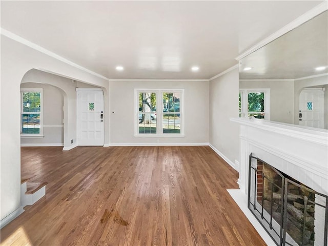 unfurnished living room with hardwood / wood-style floors and crown molding