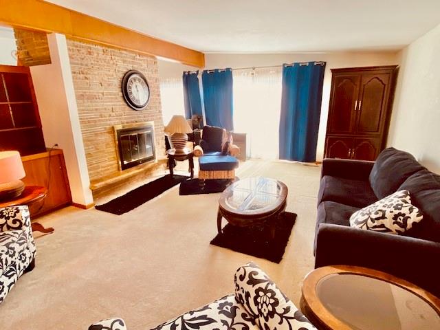 carpeted living room featuring a fireplace