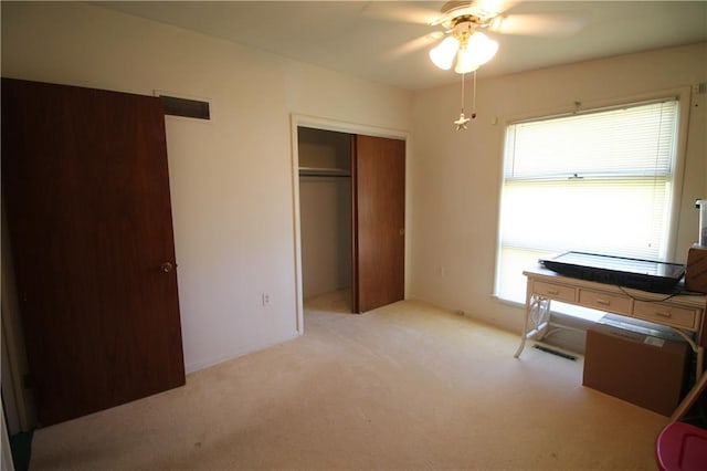 carpeted bedroom featuring ceiling fan and a closet