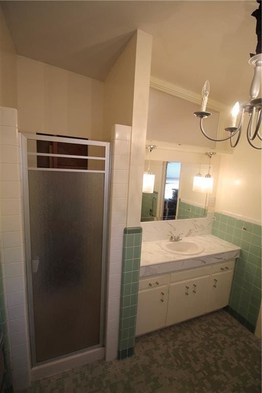 bathroom with tile walls, vanity, crown molding, and a shower with shower door