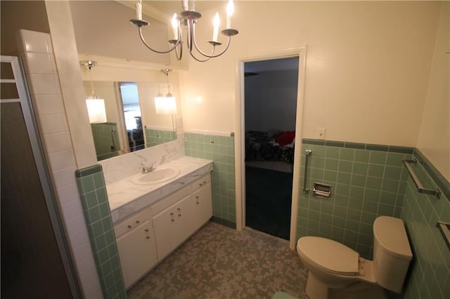 bathroom featuring ornamental molding, a chandelier, vanity, toilet, and tile walls