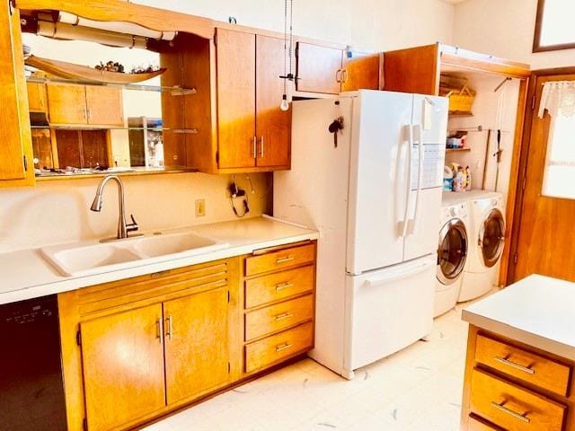 kitchen featuring washing machine and clothes dryer, white fridge, sink, and black dishwasher