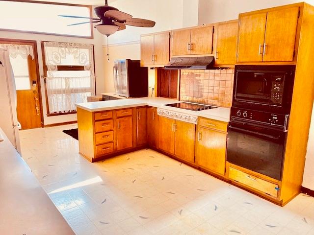 kitchen featuring kitchen peninsula, black appliances, ceiling fan, and backsplash