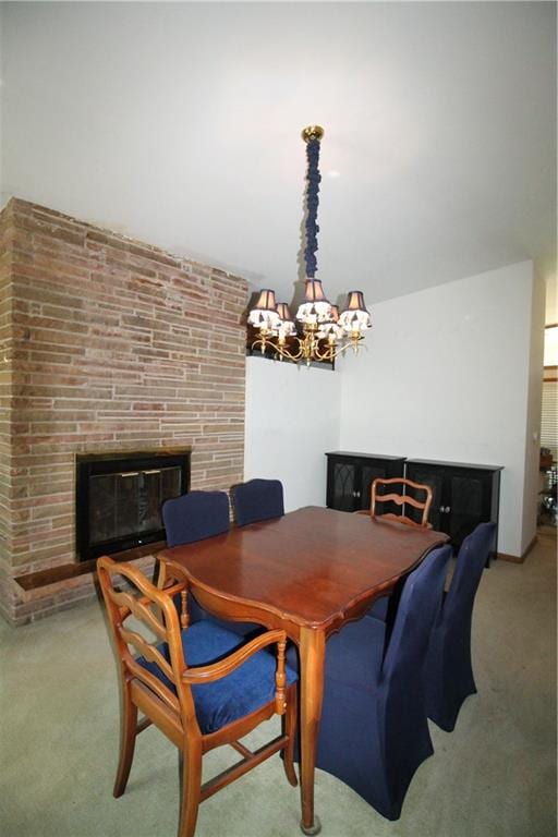 dining room featuring a fireplace, light colored carpet, and a notable chandelier