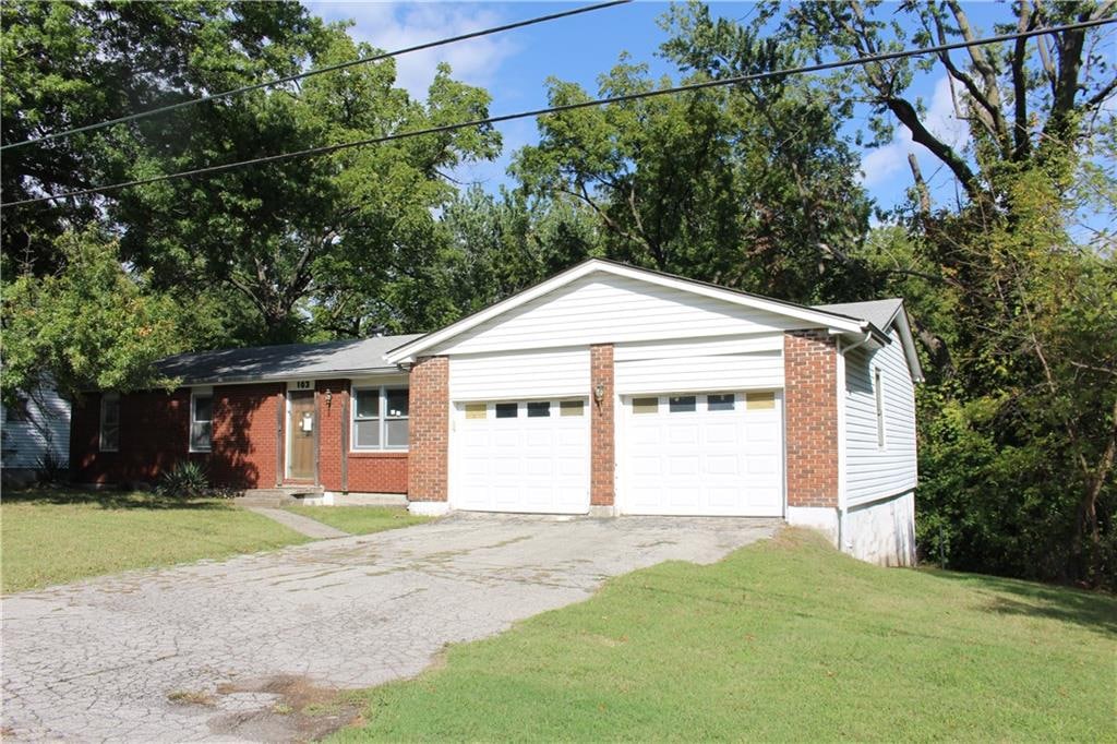 single story home featuring a front lawn and a garage