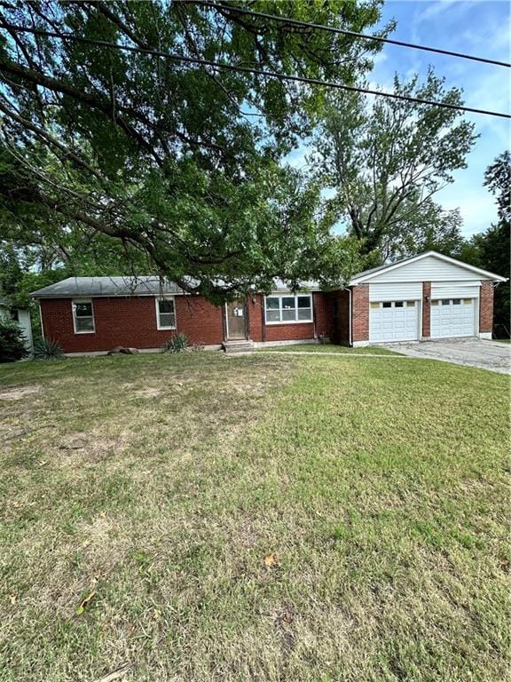 ranch-style house featuring a garage and a front lawn