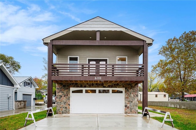 view of front of property with a balcony, a front yard, and a garage