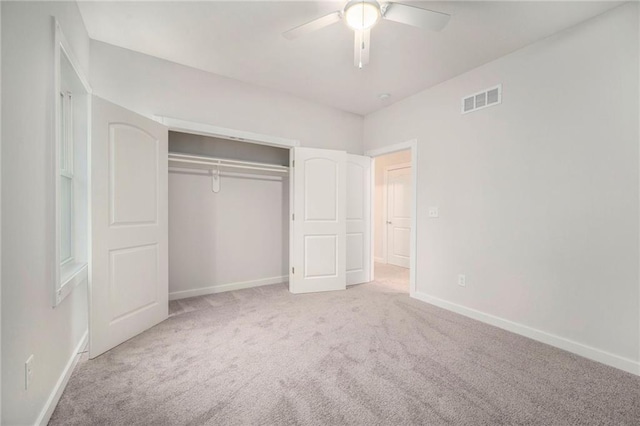 unfurnished bedroom with light carpet, a closet, and ceiling fan