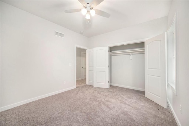 unfurnished bedroom featuring ceiling fan, a closet, and light colored carpet