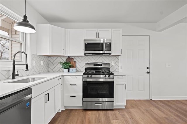 kitchen featuring white cabinets, light wood-type flooring, stainless steel appliances, and sink