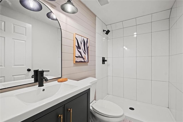 bathroom featuring tiled shower, vanity, and toilet