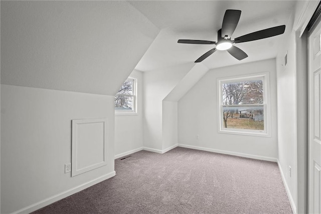 bonus room with carpet flooring, plenty of natural light, lofted ceiling, and ceiling fan