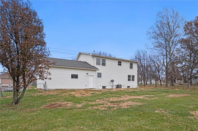 back of house featuring a lawn and central air condition unit