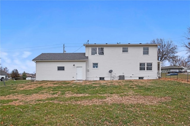 rear view of property featuring central air condition unit and a lawn