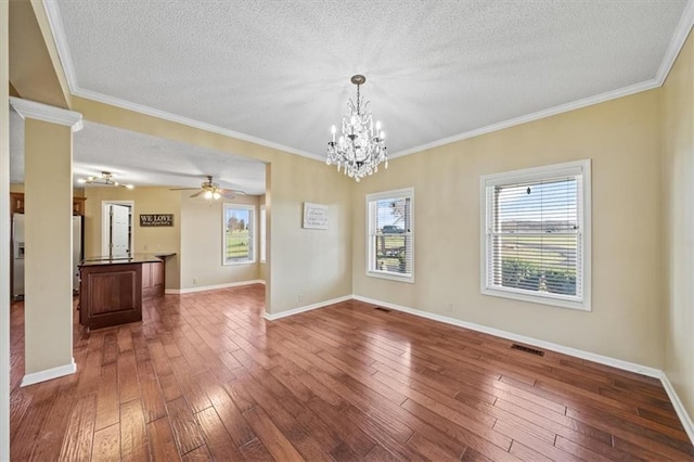 spare room with crown molding, a textured ceiling, and hardwood / wood-style flooring