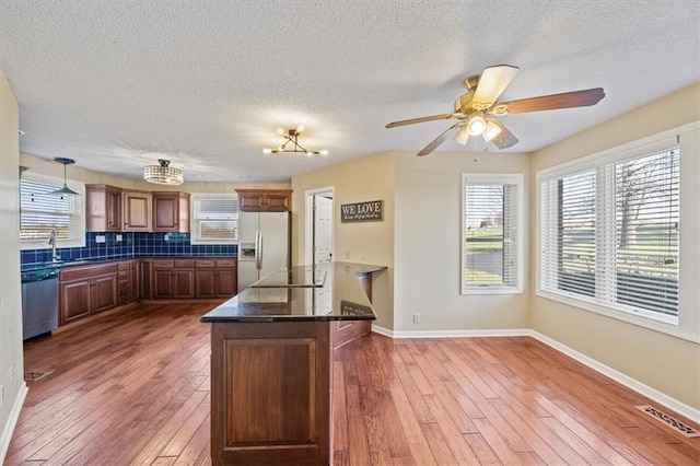 kitchen featuring dishwasher, hardwood / wood-style flooring, white fridge with ice dispenser, and hanging light fixtures