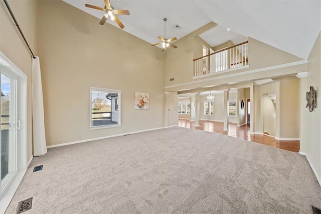 unfurnished living room with light carpet, high vaulted ceiling, and ceiling fan