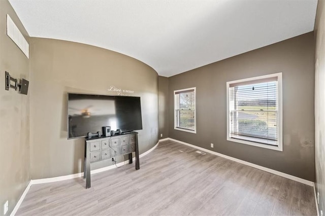 unfurnished living room with hardwood / wood-style flooring and vaulted ceiling