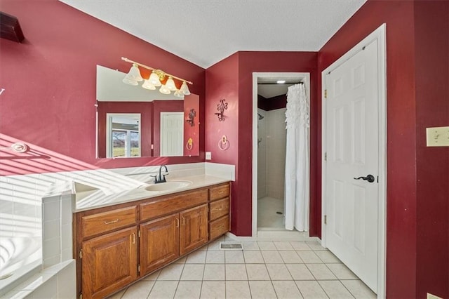 bathroom featuring tile patterned floors, vanity, and a tile shower