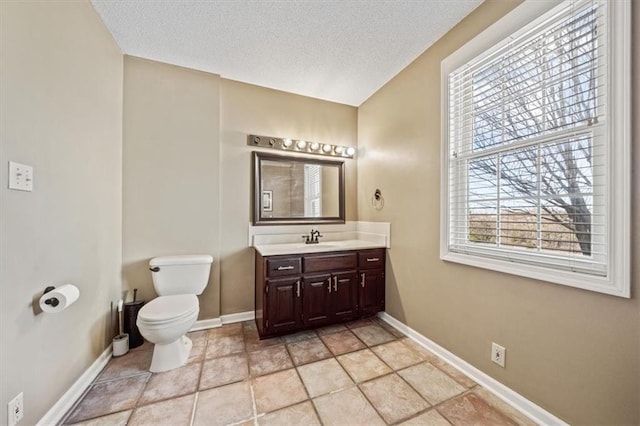 bathroom featuring vanity, a textured ceiling, and toilet