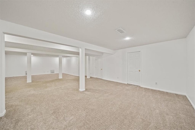 basement with light colored carpet and a textured ceiling