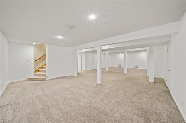 basement with a textured ceiling and light carpet