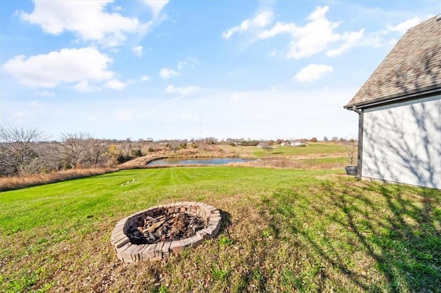 view of yard with a water view and a fire pit