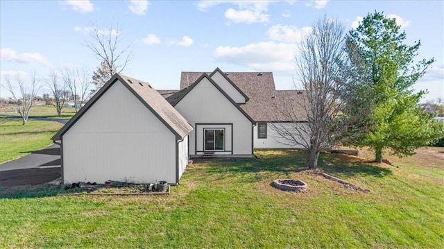 rear view of house featuring a lawn and a fire pit