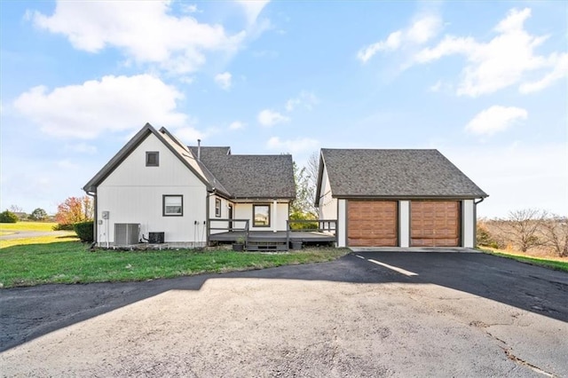 view of front of property with a front yard, cooling unit, and a wooden deck