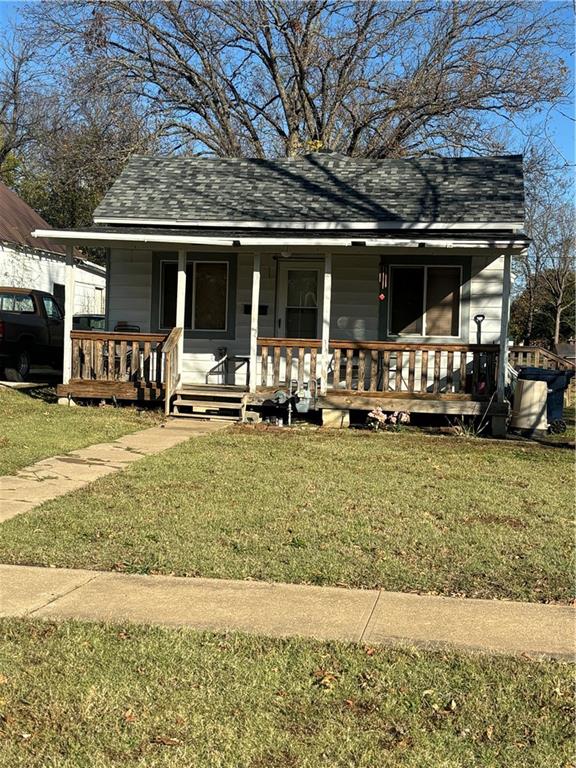 bungalow with a porch and a front lawn