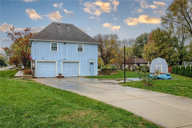 view of side of property with a yard, a shed, and a garage