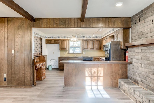 kitchen with beamed ceiling, kitchen peninsula, light hardwood / wood-style flooring, and wood walls