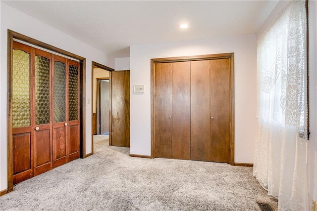 unfurnished bedroom featuring multiple windows and light colored carpet