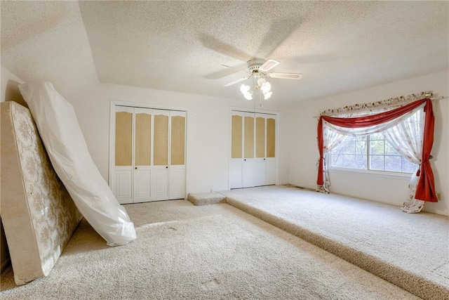 unfurnished bedroom featuring a textured ceiling, carpet floors, and ceiling fan