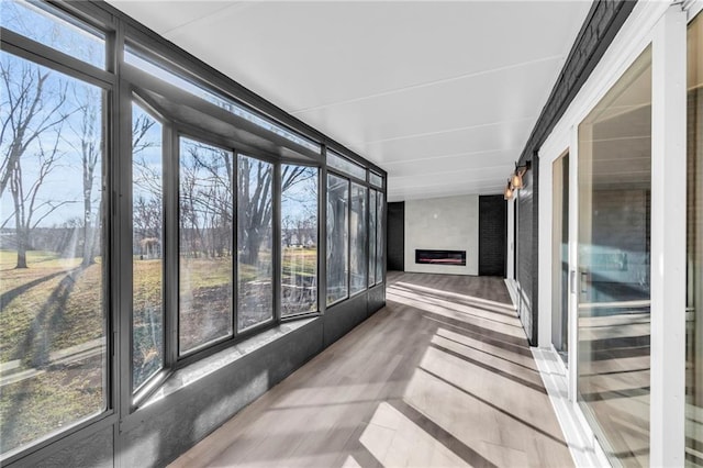 unfurnished sunroom featuring a large fireplace