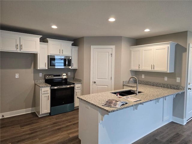 kitchen with white cabinetry, kitchen peninsula, stainless steel appliances, and sink