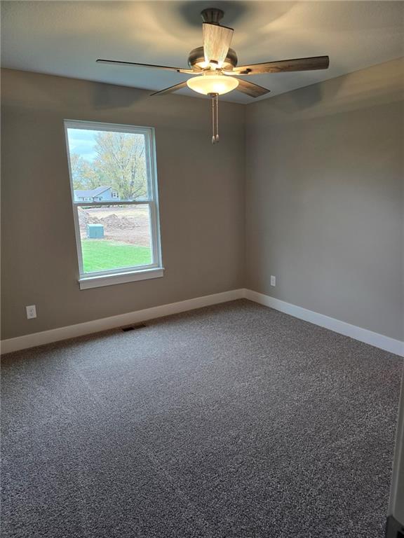 carpeted spare room featuring ceiling fan