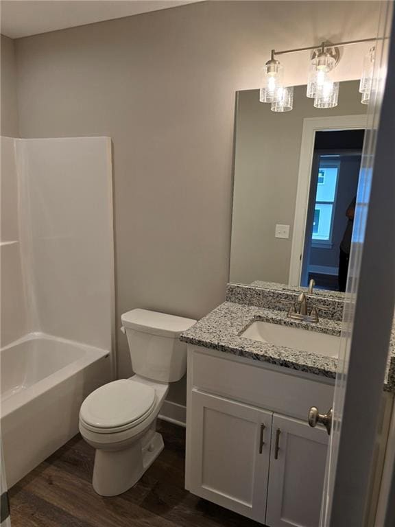 full bathroom with toilet, bathing tub / shower combination, vanity, and hardwood / wood-style flooring