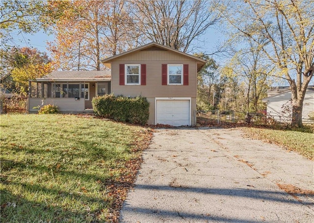 tri-level home with a garage, a front lawn, and a sunroom