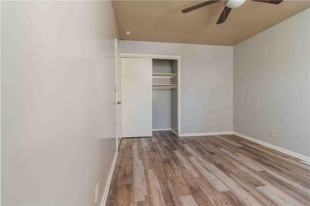 unfurnished bedroom with hardwood / wood-style flooring, ceiling fan, and a closet